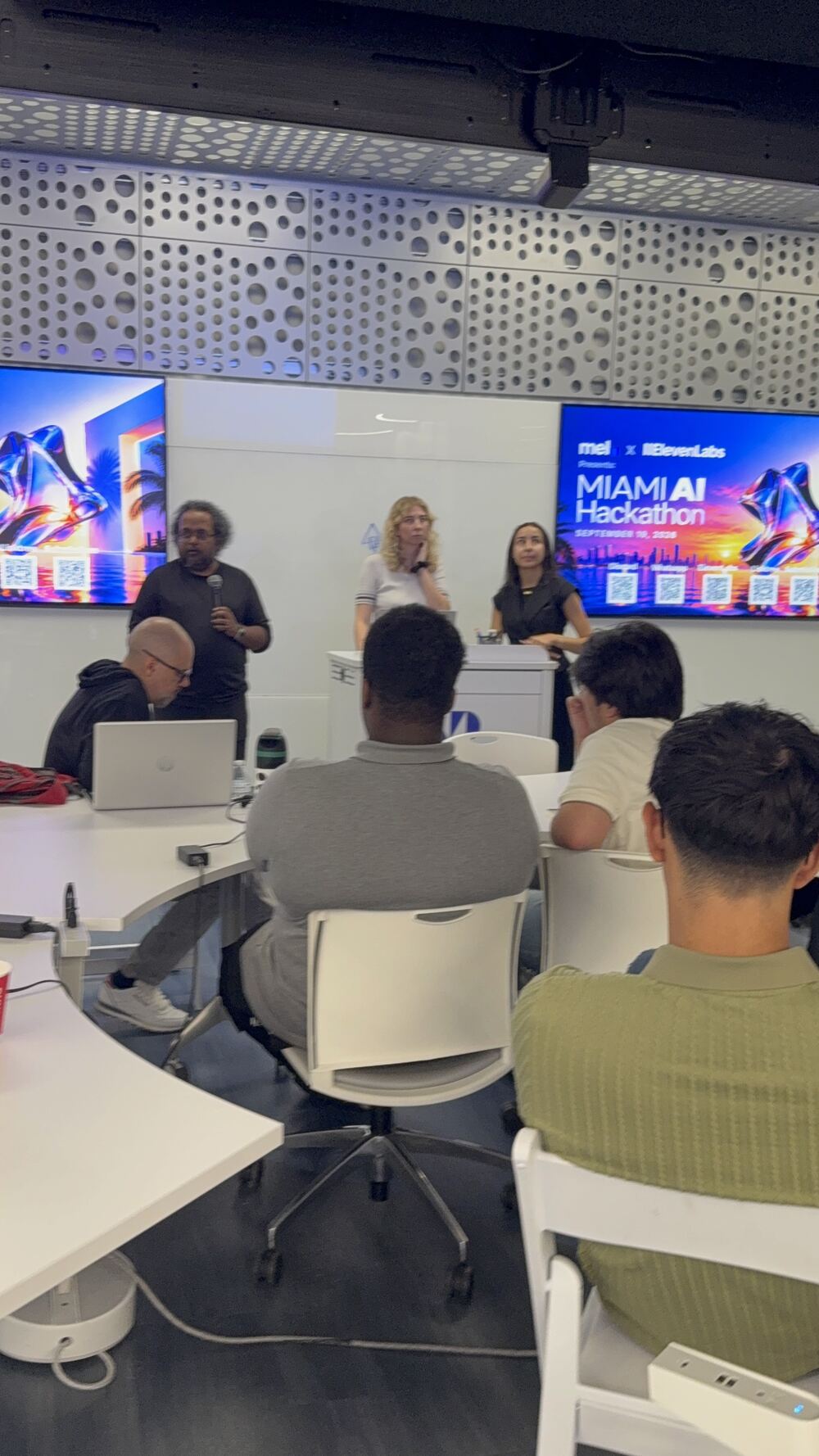 A talk on stage at the Miami AI Hackathon